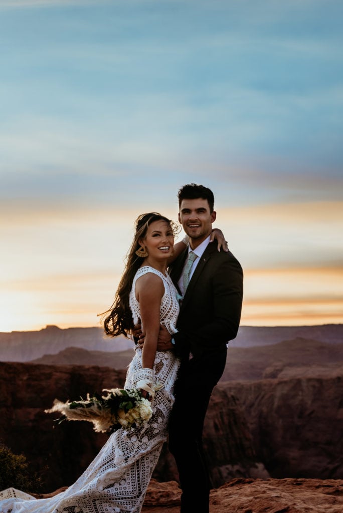 Bride and groom smile at sunset