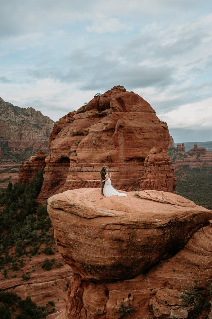 Wedding couple framed by the red rocks taken by Sedona Elopement Photographer Stratus Adventure Photography
