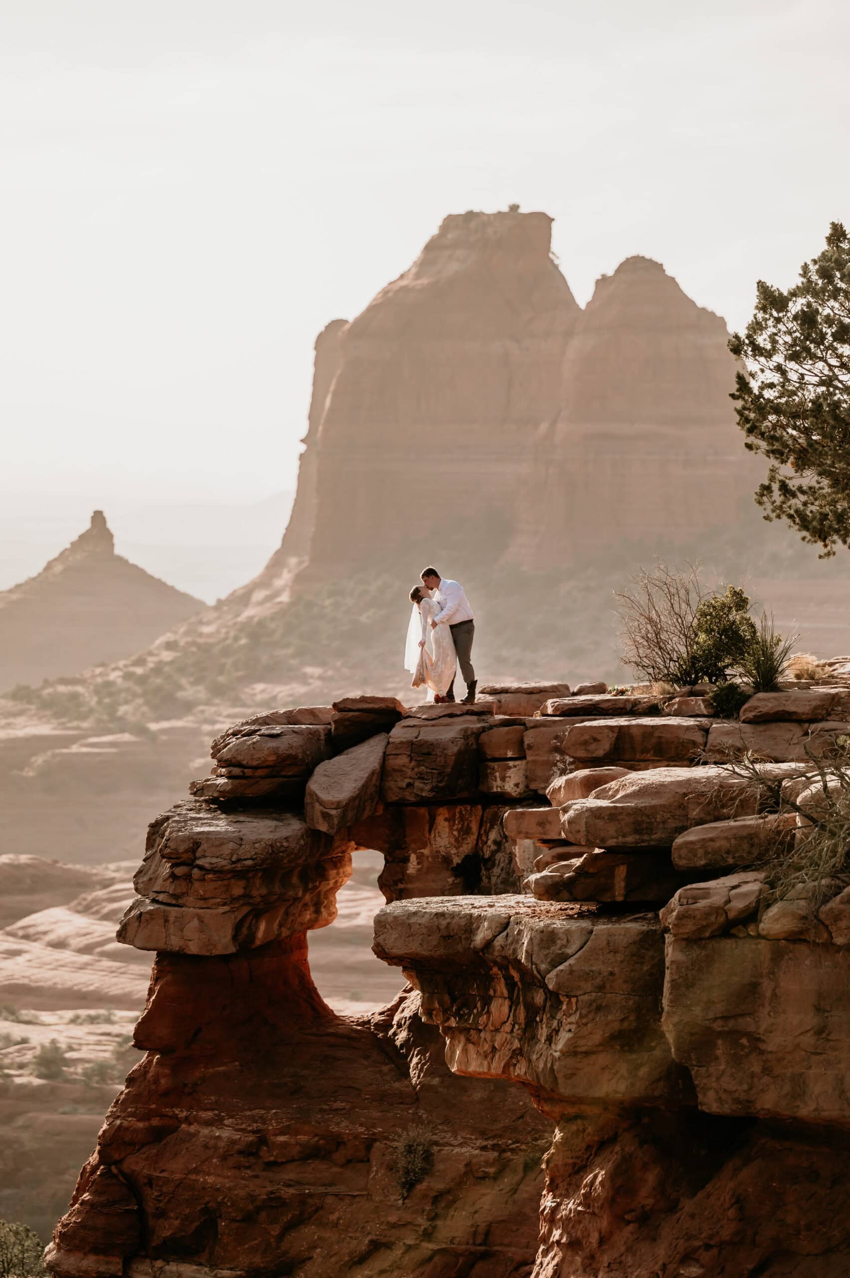 couple kissing cliffiside at Merry Go Round Rock by Sedona Wedding Photographer Stratus Adventure Photography