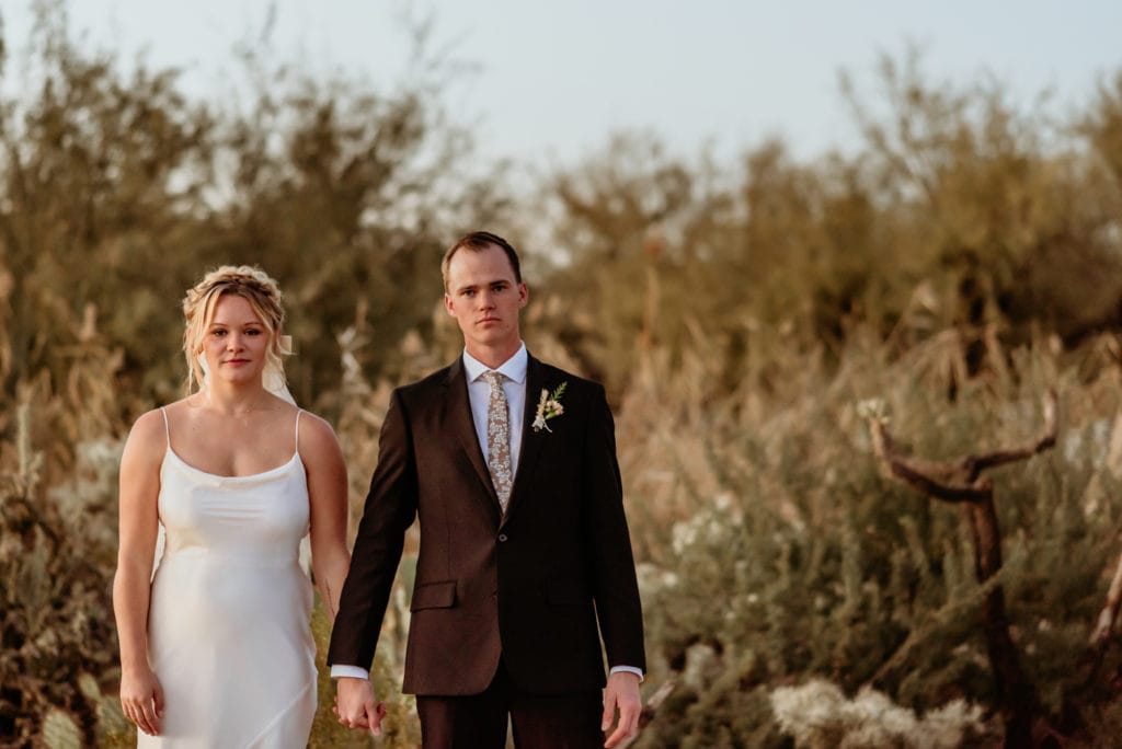 Serious pose as the sun sets during this desert elopement