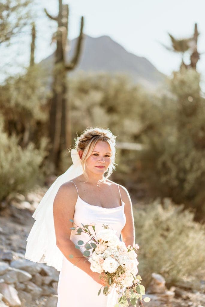 Bride in front of saguaro cacti in the Arizona desert