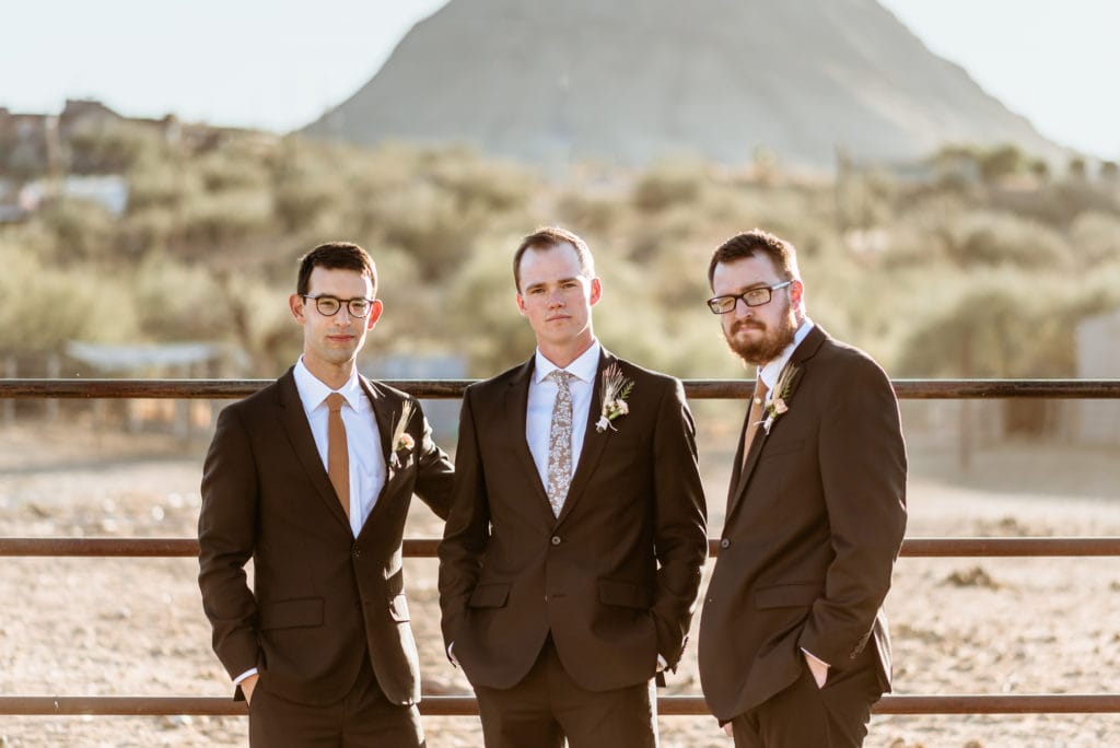 Groom with his brother and best man in front of the horse fence at Wranglers Roost in New River, Arizona