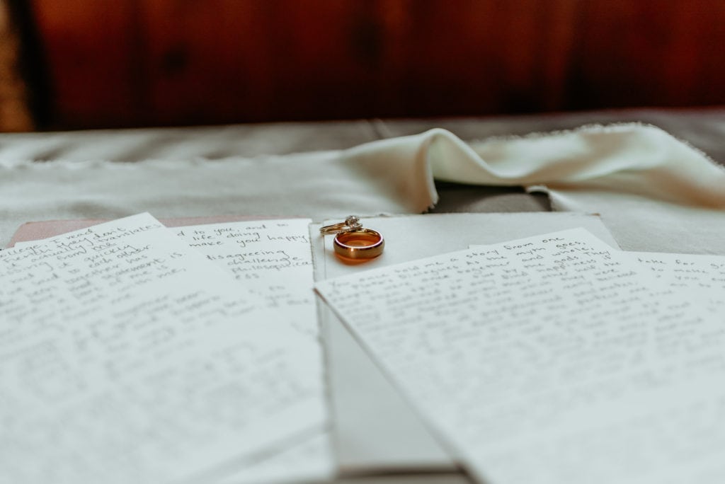 His and hers wedding bands placed on handwritten vows