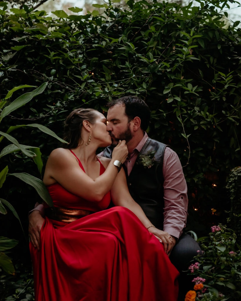Wedding couple kissing on the bench in one of the courtyards during their intimate Tucson Botanical Gardens Wedding