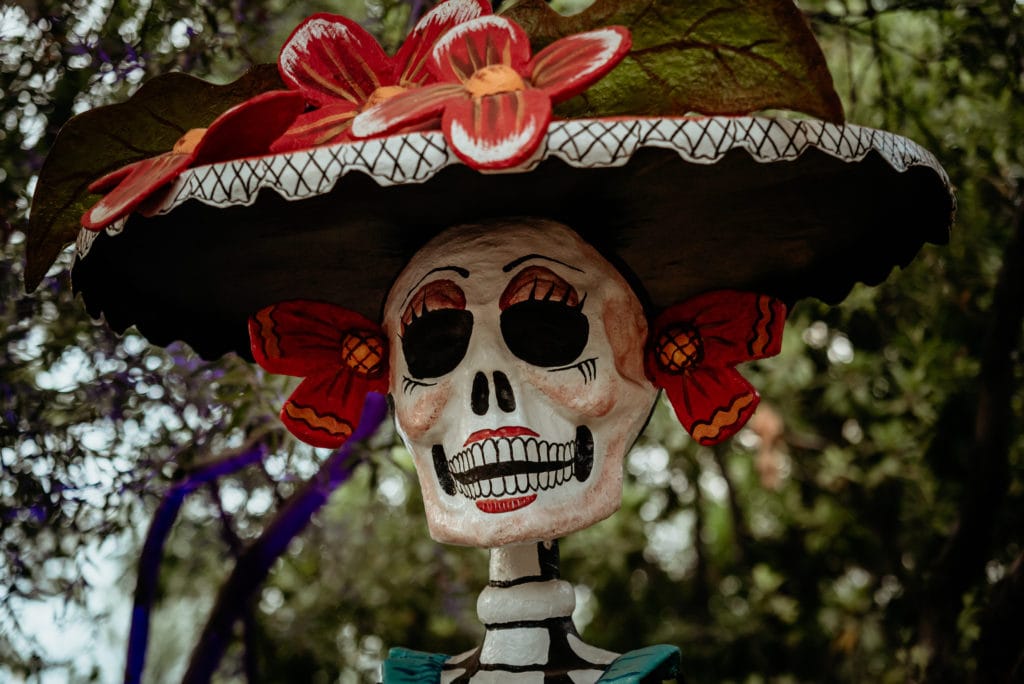 Beautiful Dia De Los Muertos sculpture with bright red flowers at the Tucson Botanical Gardens art exhibit