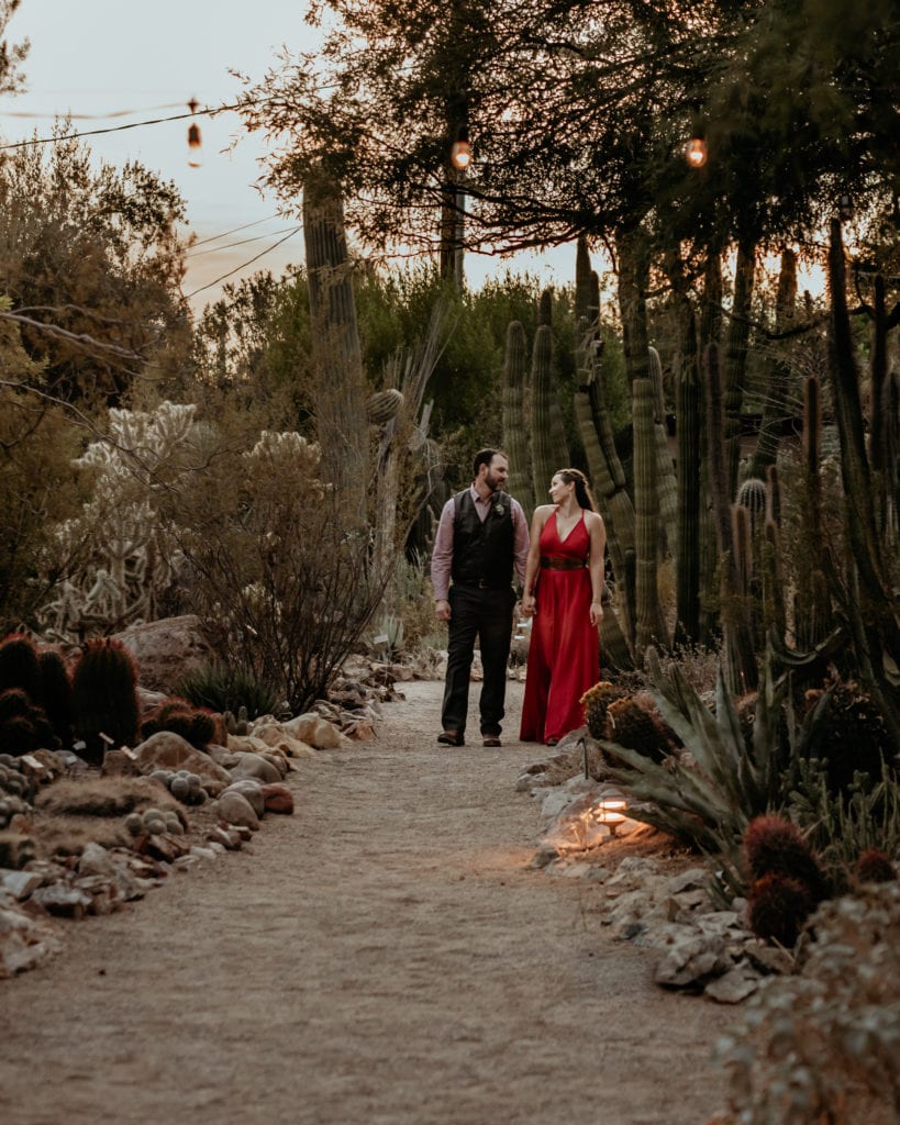 Wedding couple walking down the dirt path surrounded by cacti during their Tucson Botanical Gardens Wedding