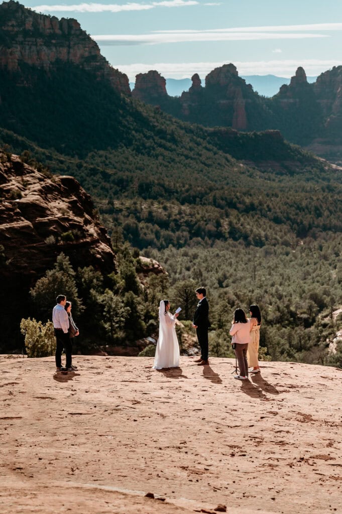 eloping couple exchanging vows overlooking red rock canyons
