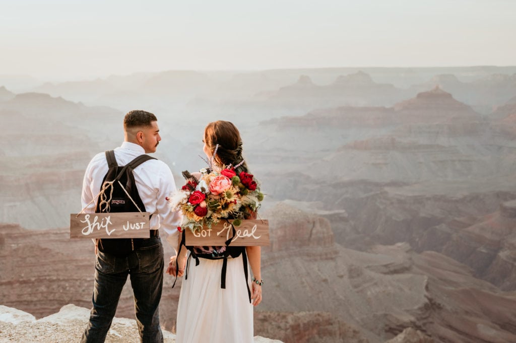 Couple with their gear in their backpacks overlooking the Grand Canyon rim during Arizona elopement captured by Stratus Adventure Photography