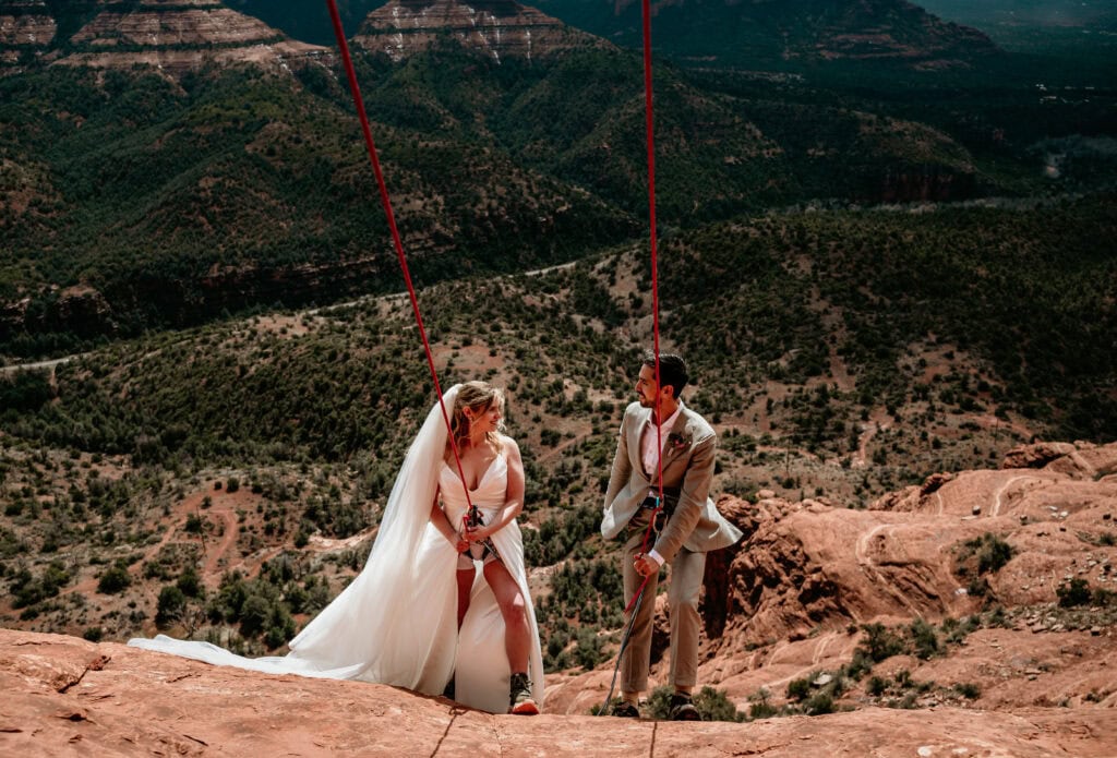 Couple eloping in Arizona choose to rappel down the side of a mountain in Sedona as an adventurous activity