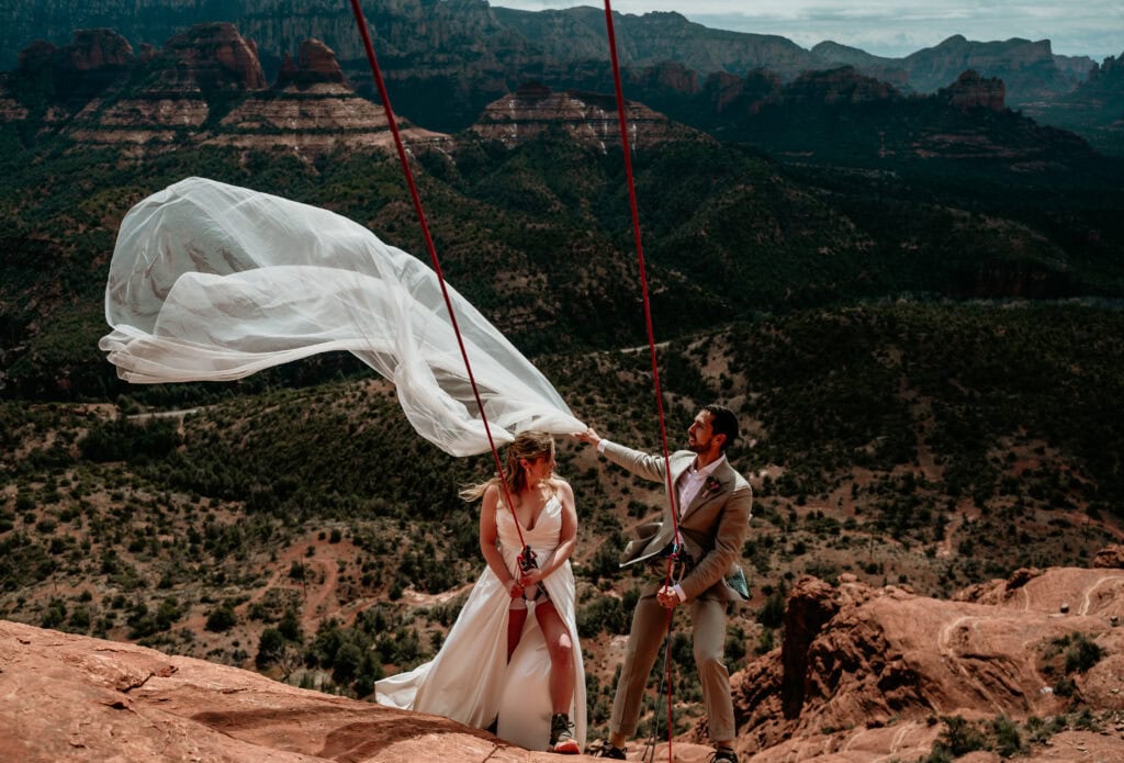wind blowing veil during Sedona rock climbing Elopement