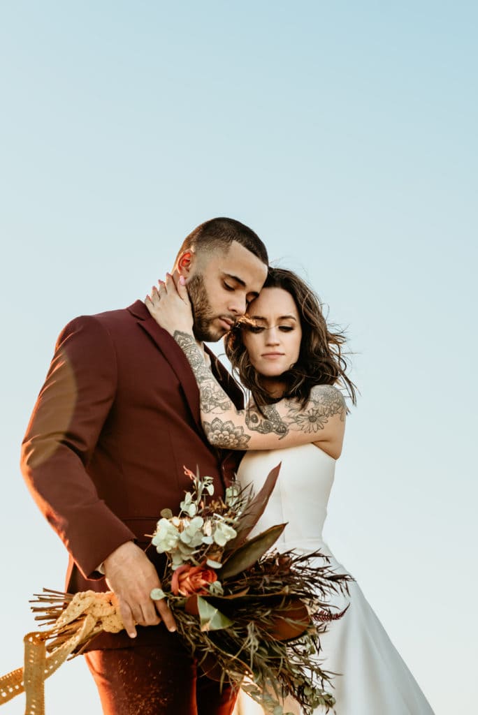 Madly in love elopement couple embrace during their Bohemian wedding