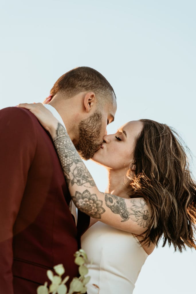 Madly in love intimate kiss at sunset during Imperial Sand Dune wedding