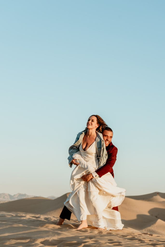 Groom grabbing his wife to spin her through the air