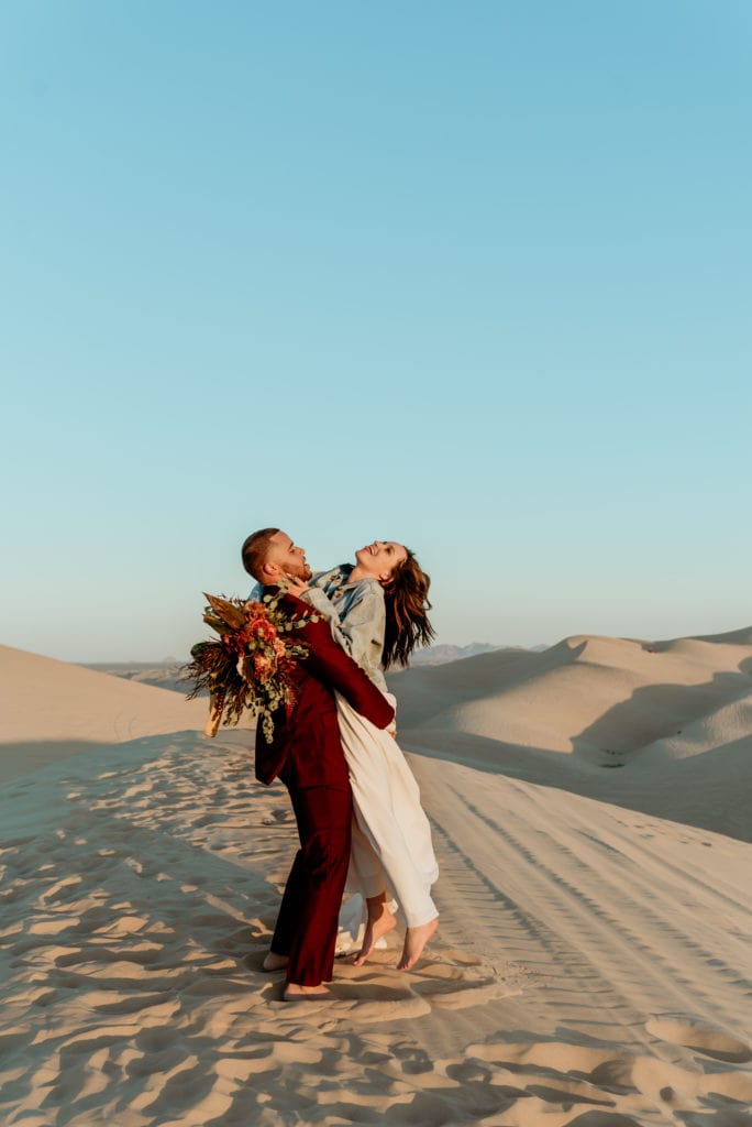 Groom spins his barefoot wife during their Glamis Sand Dune elopement