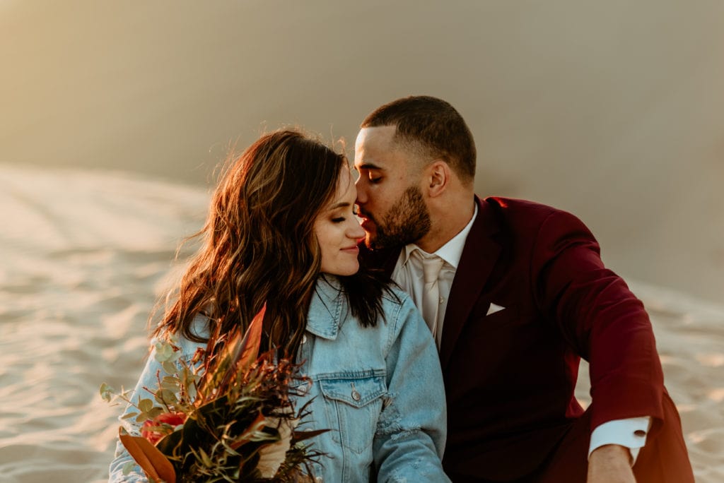 Groom whispers in his wife's ear as the sun sets on this Imperial Sand Dune wedding