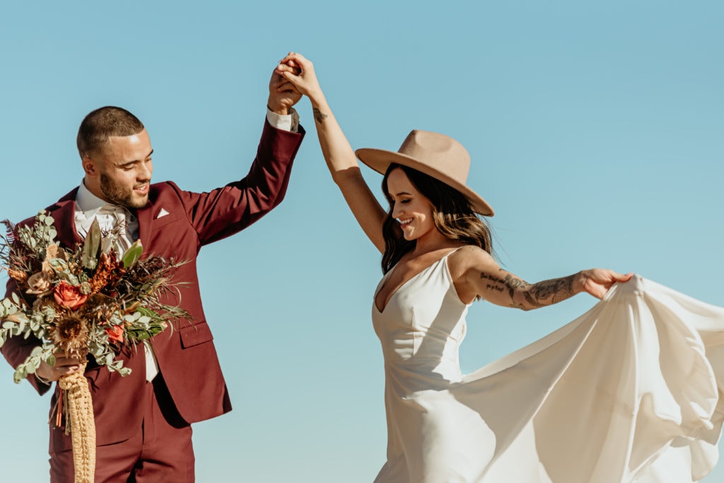Bride and groom dance in the desert sun