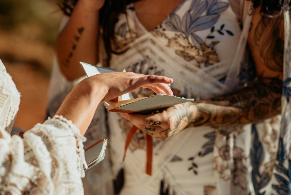 Delicate tracing of vow book during Sedona elopement