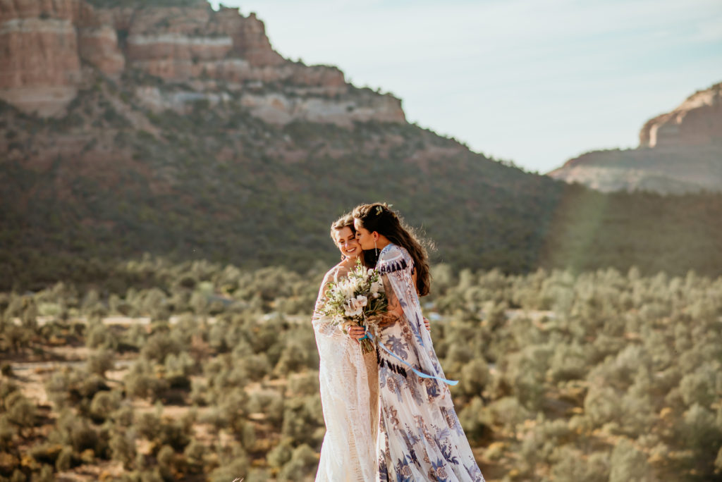 Brides embrace as the warm sun glow surrounds them