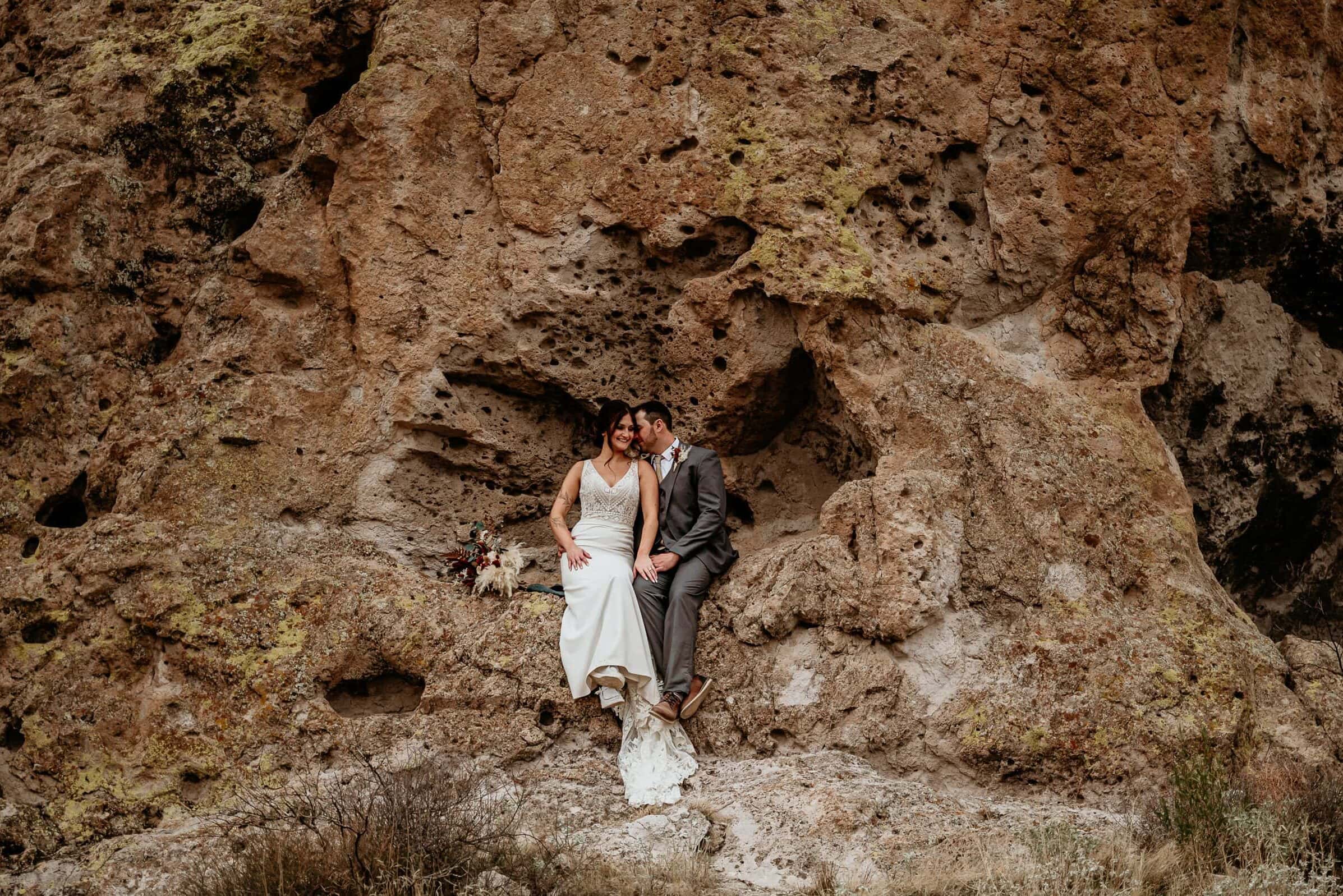 Couple sitting in a natural bench during their Phoenix elopement, shot by Stratus Adventure Photography
