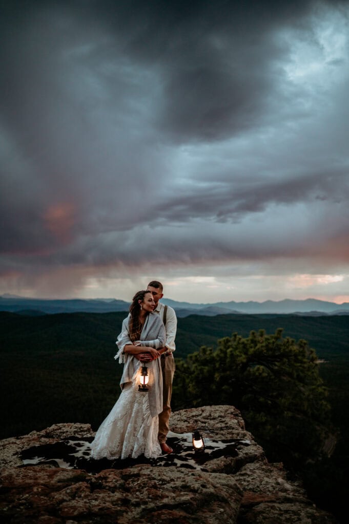 Couple embracing with a stormy sky during blue hour at their Mogollon Rim for Arizona elopement by Stratus Photography