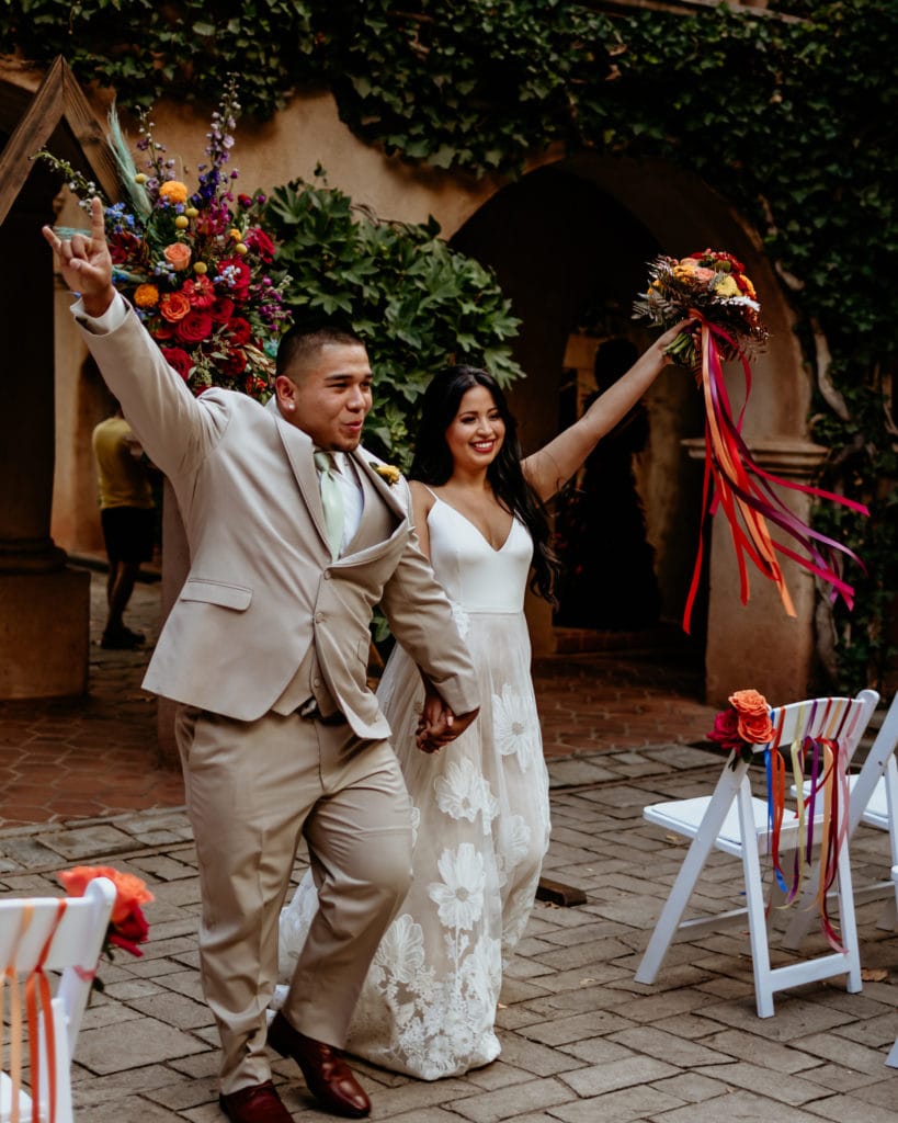 Bride and groom celebrating as they come down the isle