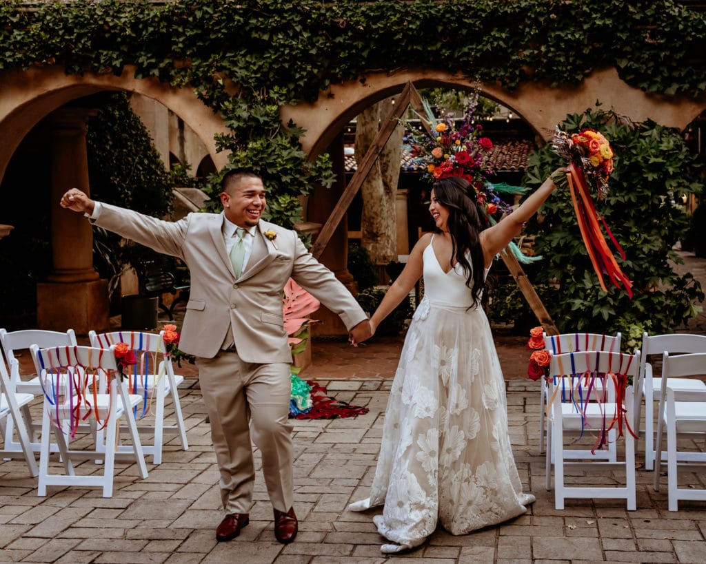 Bride and groom celebrating as they come up the isle
