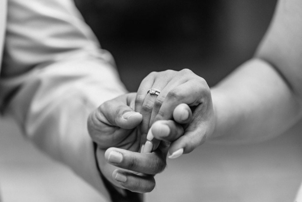 Detail shot of bride and groom holding hands