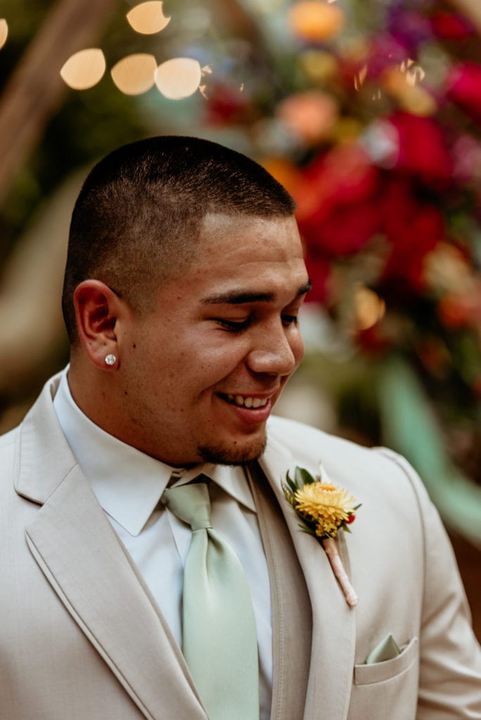 Groom in tan suit with yellow boutonniere