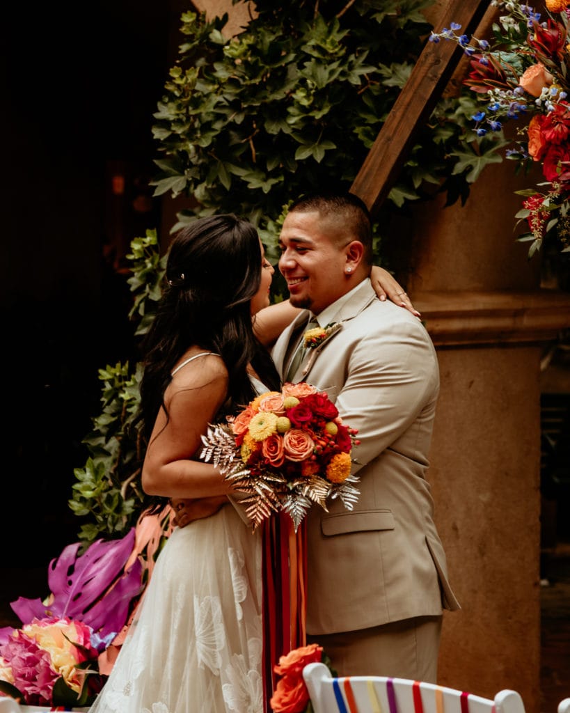 Bride and groom dancing in front of ivy lined walls