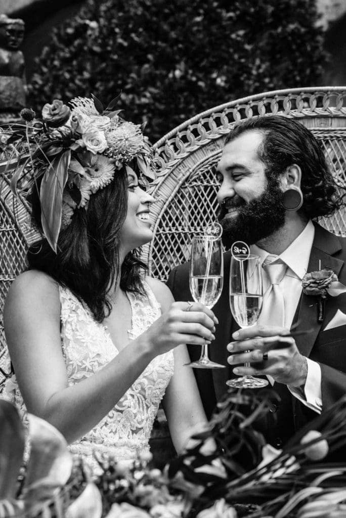 Bride and Groom enjoy a laugh and a drink as they look at each other during their wedding reception