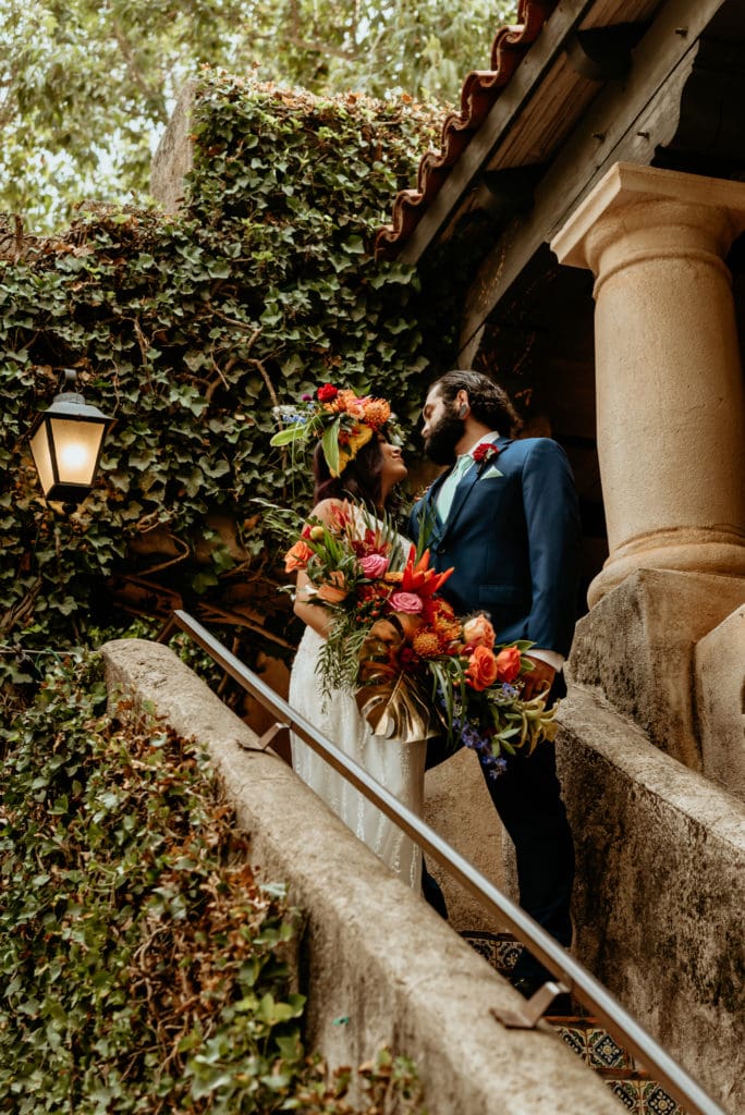 Bride and groom surrounded by ivy covered stucco walls in the Tlaquepaque courtyard