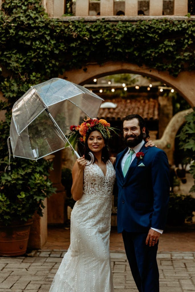 Bride and groom smiling in the light rain at Tlaquepaque in Sedona