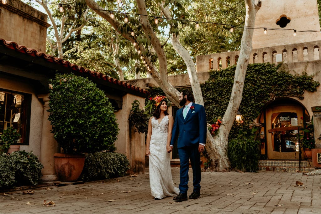 Bride and groom stepping through the shaded courtyard