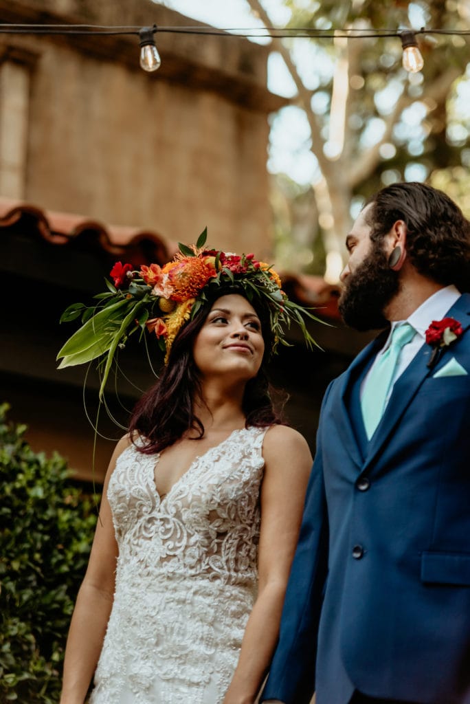 Bride smiling at her groom wearing a navy blue suit