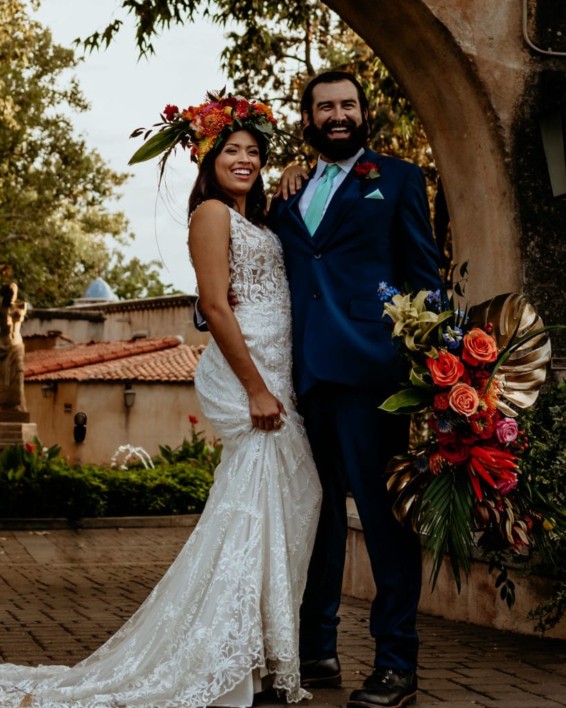 Wedding couple laughing in front of the main Tlaquepaque entrance