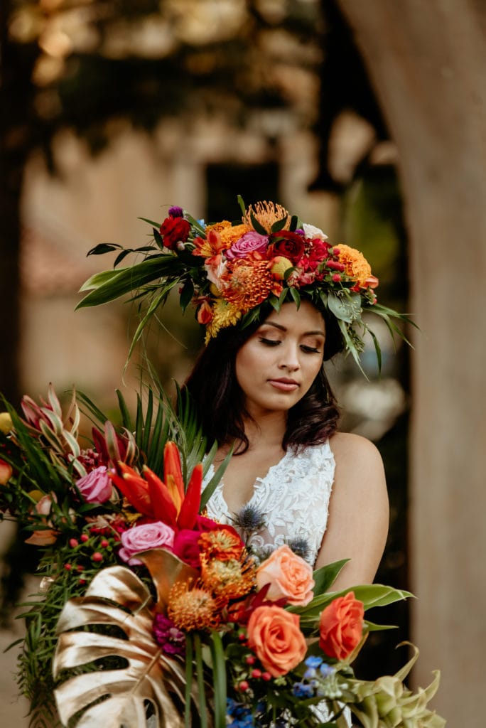 Bride looking down at her colorful tropical bouquet