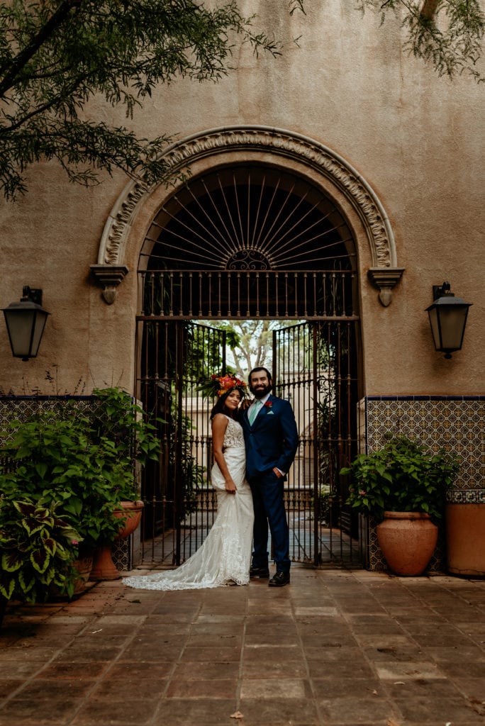 Bride and groom portrait in front of Spanish gates and tiled walls