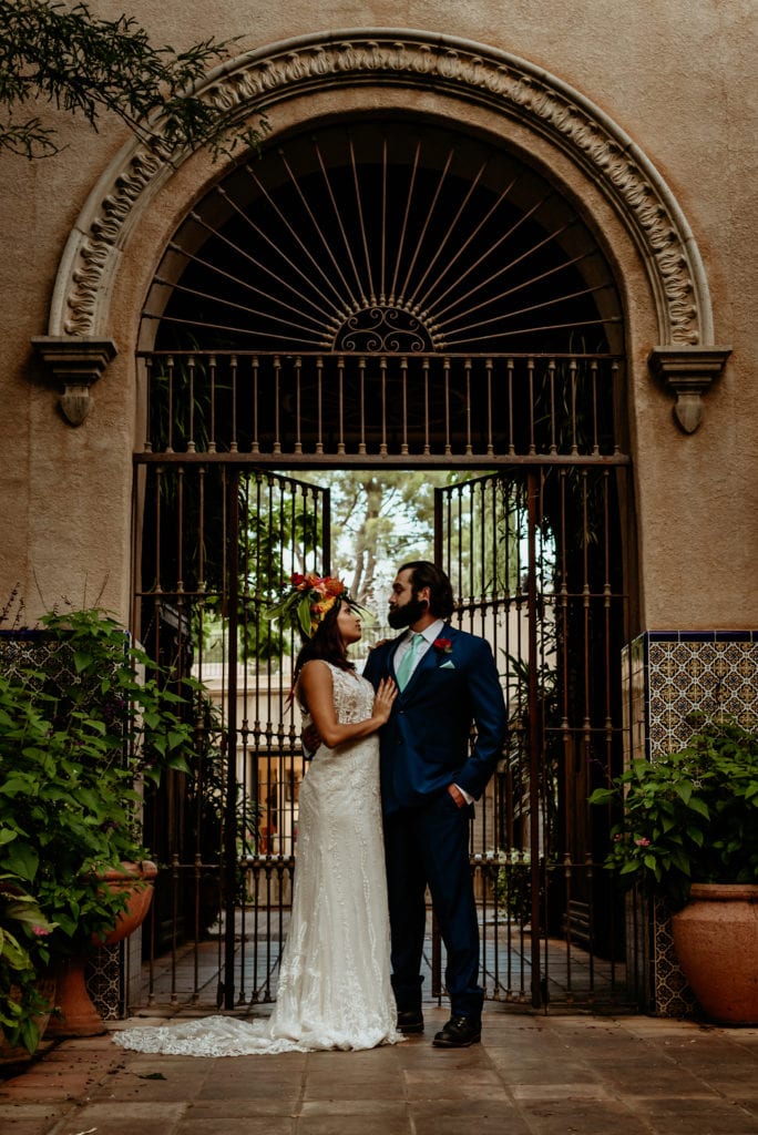 Wrought iron gate towering behind wedding couple