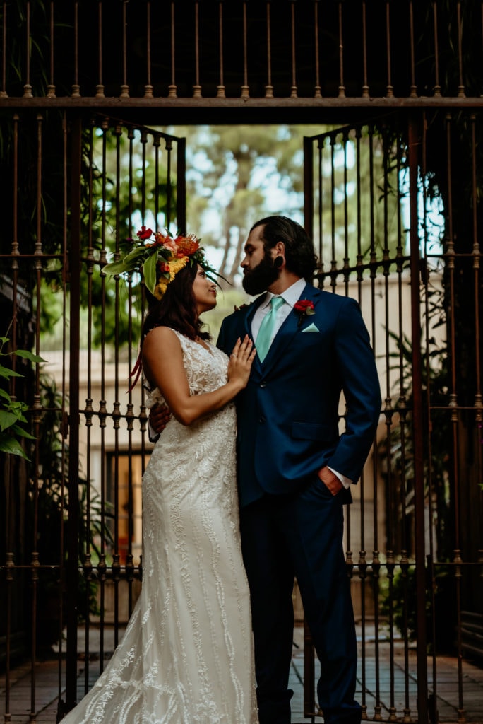 Bride and groom gazing into each others eyes in front of wrought iron gates