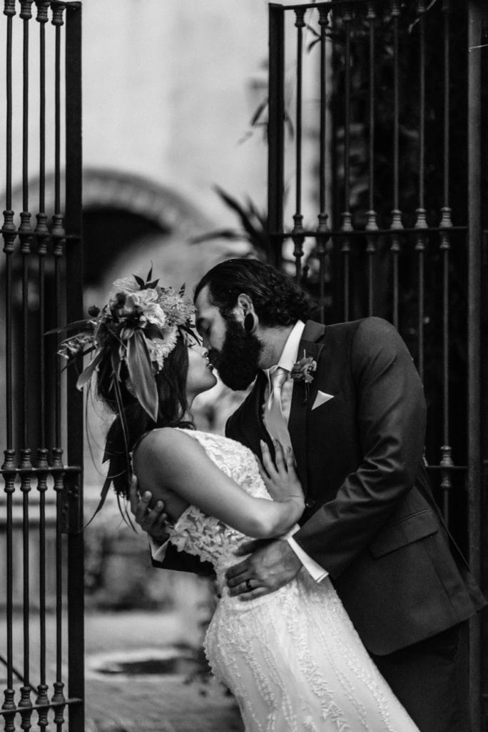 Black and white portrait of groom dipping bride into a kiss