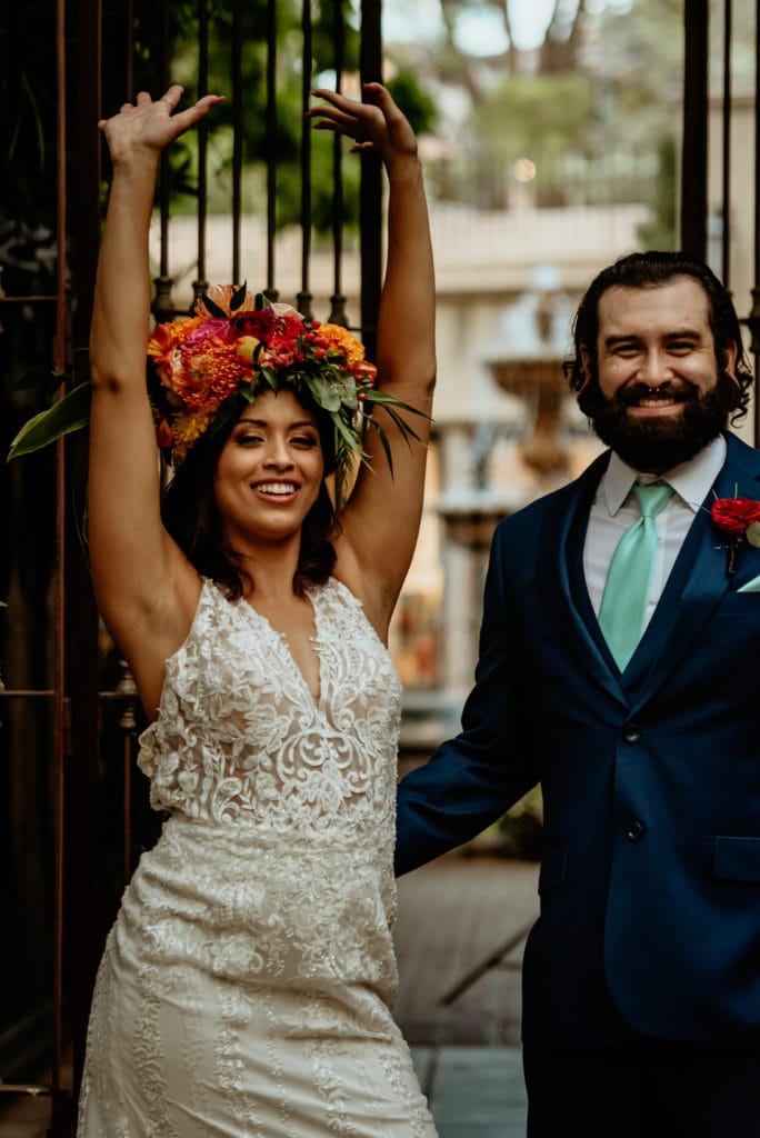 Bride celebrating by throwing her hands in the air smiling