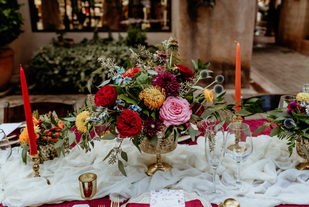 Beautiful vibrant floral arrangements on reception table in Tlaquepaque courtyard