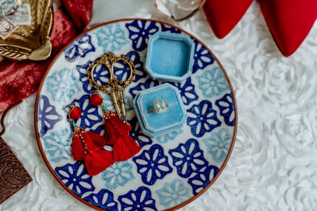 Beautiful blue and white Spanish tile clay plate with engagement ring and bright red tassel earings