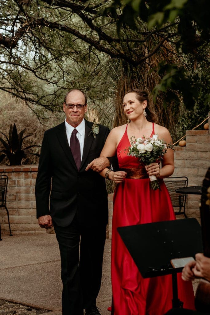 Bride walking down the isle in her bright red dress