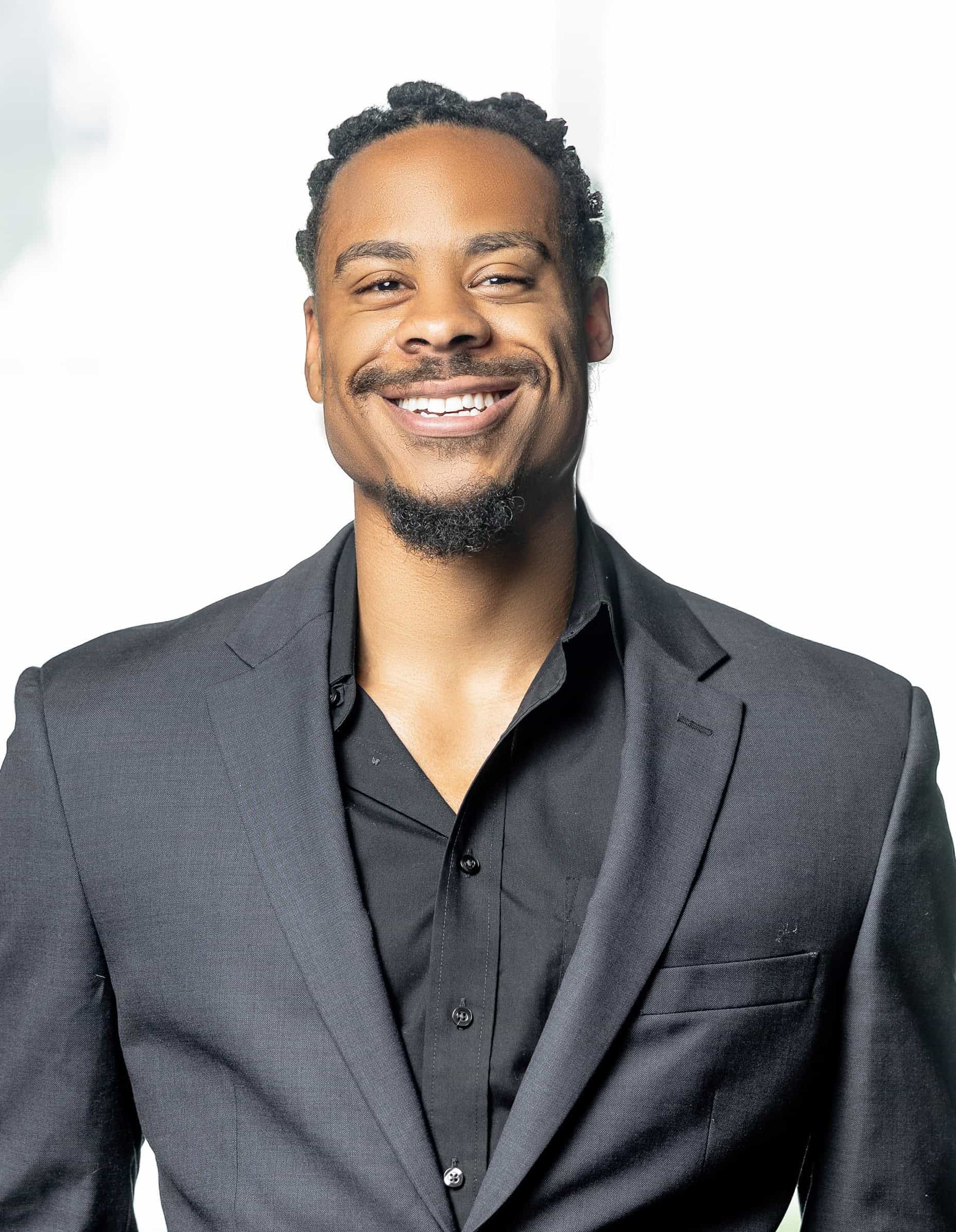 Professional man in a suit smiling for a corporate photo.