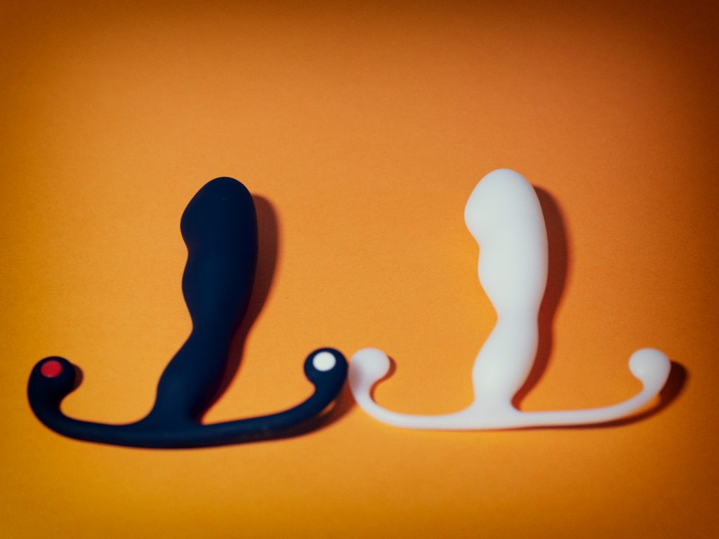 De aneros helix syn trident en aneros helix trident naast elkaar. Het is moeilijk de verschillen tussen deze twee prostaatstimulators te zien, behalve dan dat de aneros helix syn trident gemaakt is van silicone en de helix trident van nylon