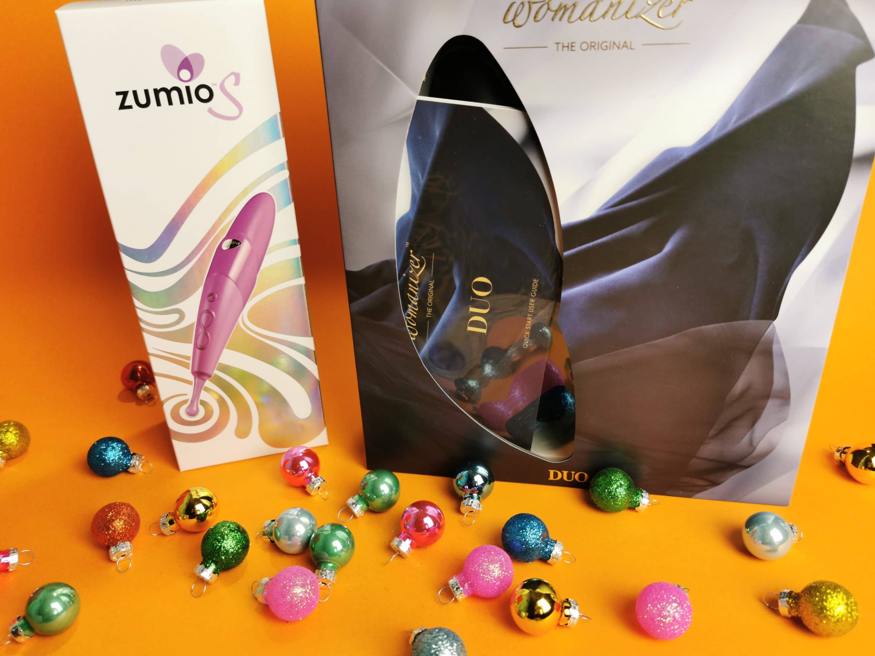 De Zumio S en de Womanizer Duo, beiden in de verpakking met kleine kerstballen er omheen