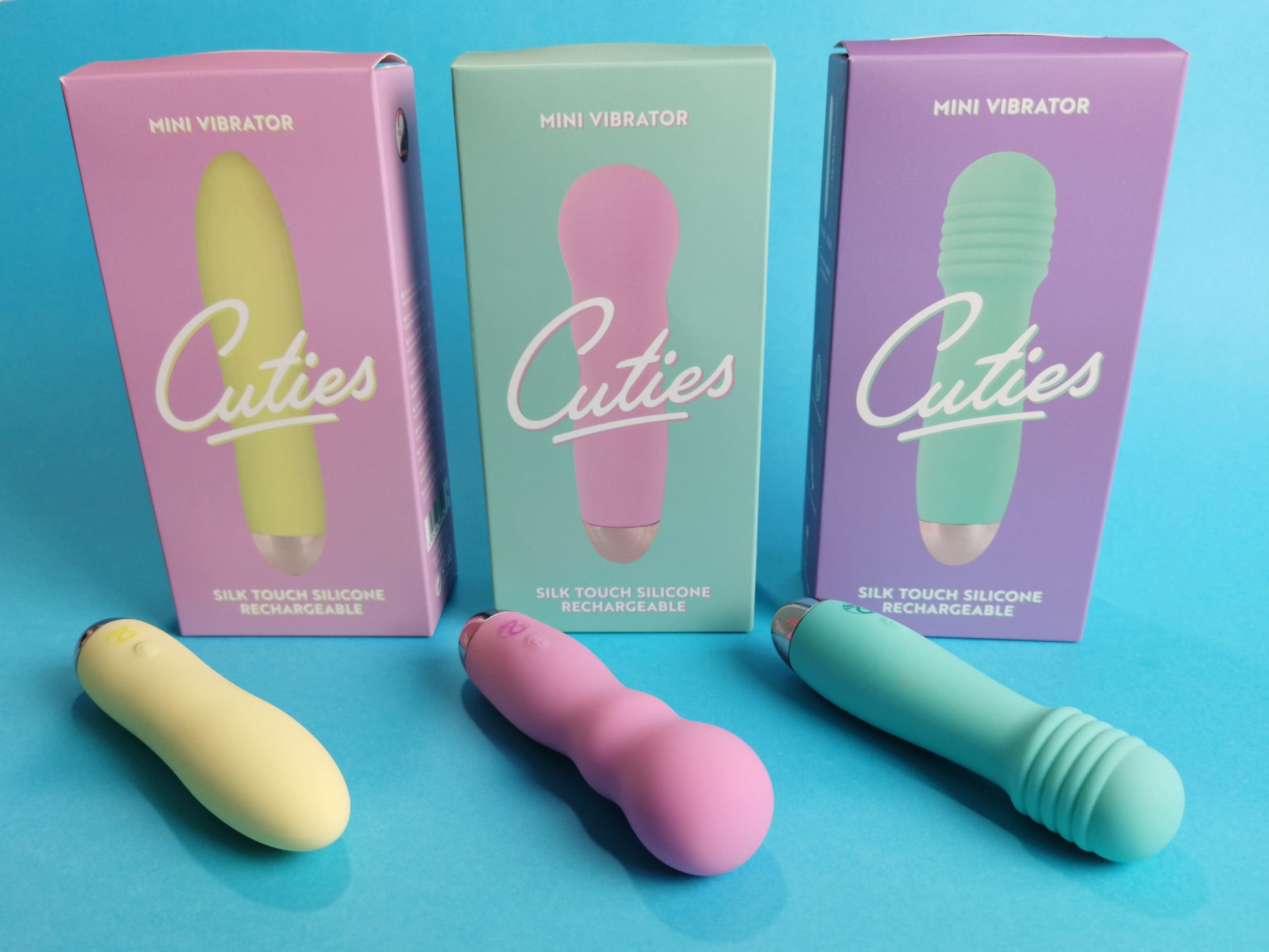 De You2Toys Cuties vibrator voor hun verpakkingen. De gele heeft een roze verpakking, de roze heeft een mintgroene verpakking en de mintgroene heeft een lila verpakking.