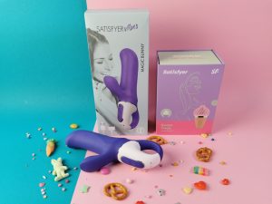 De satisfyer vibes magic bunny en zijn verpakking met daarnaast een andere toy van satisfyer in de nieuwe stijl verpakking. De nieuwe verpakking is lila met roze en mintgroen met een kleine foto van de toy en in lijnen is een vrouwfiguur getekend. Het ziet er heel cute en fris uit.