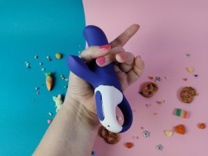 Ik heb de satisfyer vibes magic bunny in mijn hand en mijn duim en middelvinger om het inwendige deel heen. Mijn vingers overlappen elkaar.